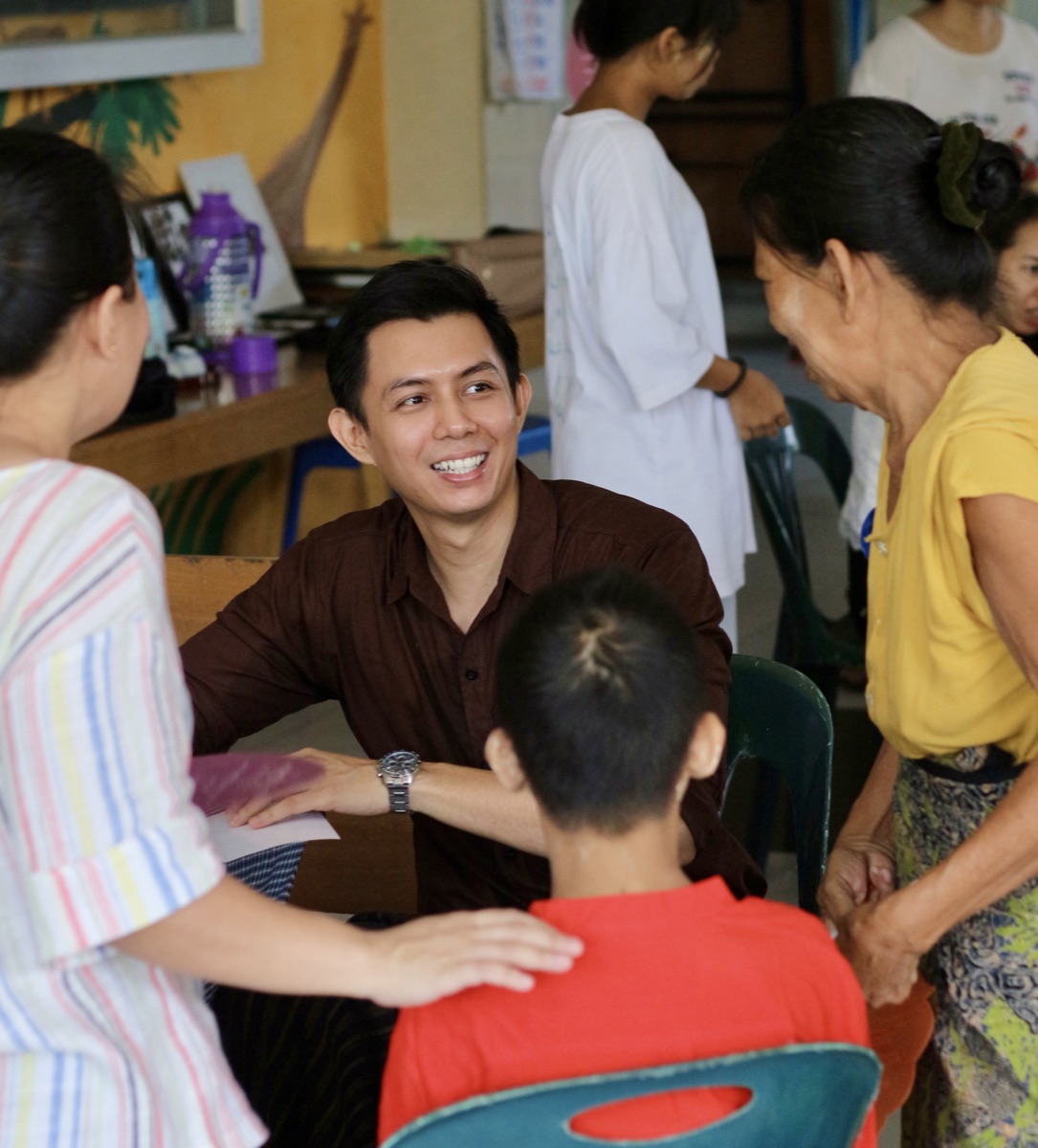 Dr. Ye Yint talking with community members, including a woman in yellow