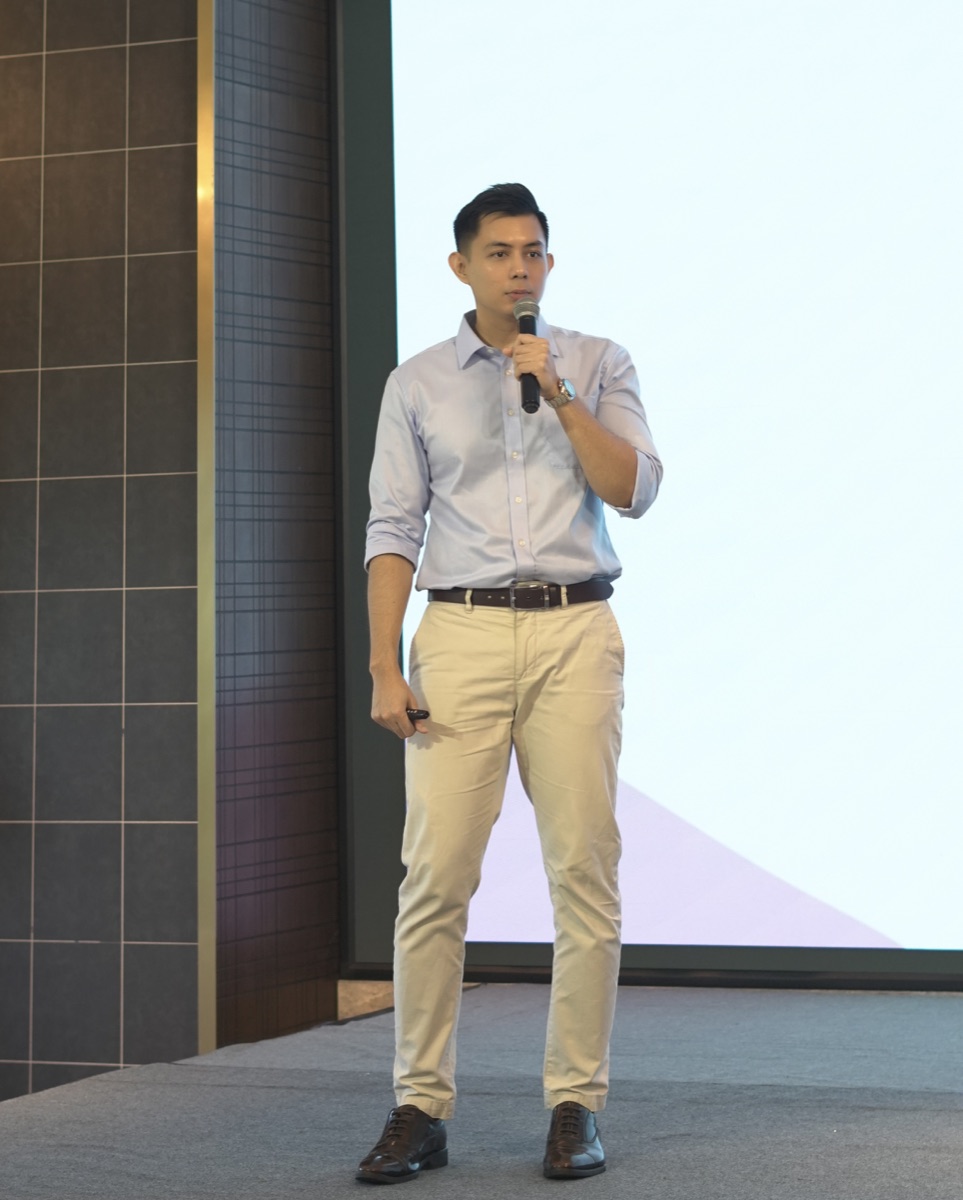 Dr. Ye Yint speaking into a microphone at a health education seminar